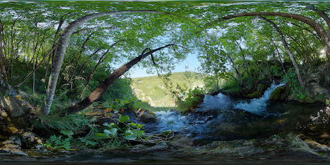 Water Cascading Over Cliff Edge In Breezy Forest