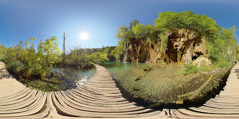 Boardwalk Approaching Waterfall Across Crystal Clear Lake