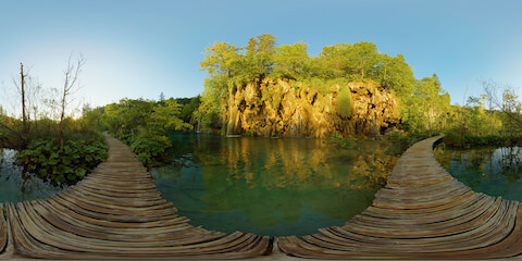 Boardwalk Across Lake Looking At Waterfall In Glowing Morning Light