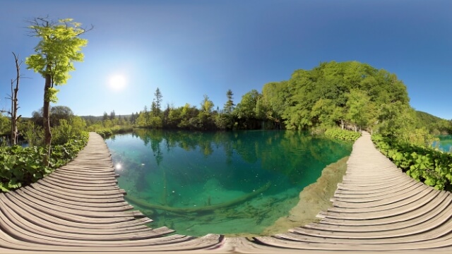 Wooden boardwalk over crystal-clear emerald lake
