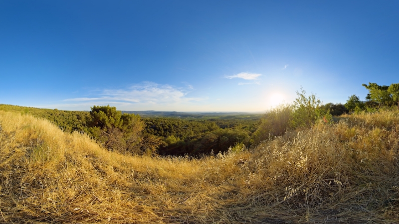 Sunset over a scenic Provençal valley with golden grass in the foreground.
